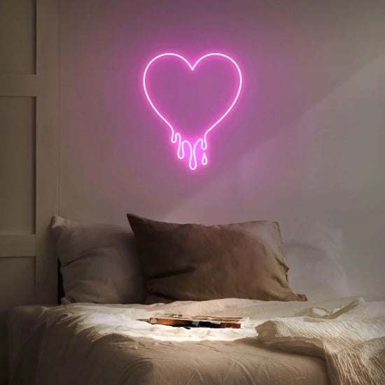 Cuore gocciolante neon pink heart-shaped wall light above bed
