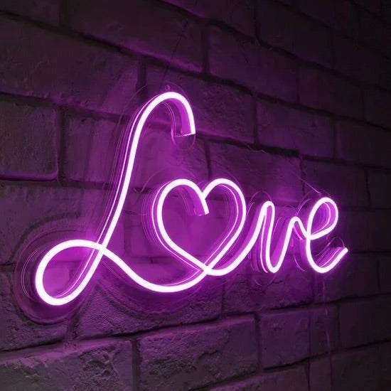Purple neon "Love" sign with heart shape on brick wall background