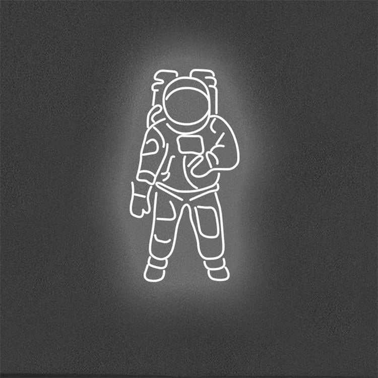 Neon light shaped like an astronaut on a dark wall