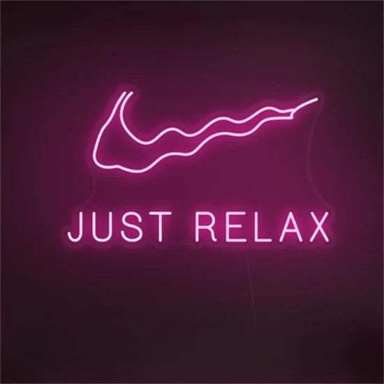 Just relax neon sign in pink with wavy design on dark background