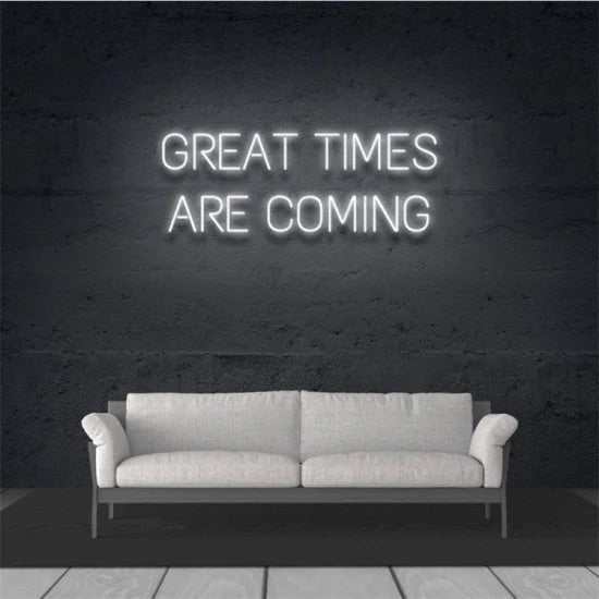Great Times are coming neon sign on dark wall above white sofa