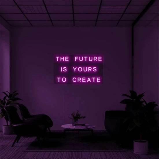 neon sign with the phrase the future is yours to create mounted on plexiglass support in a modern room with plants and chairs