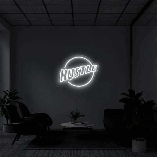 Hustle neon sign with circular design mounted on dark wall in modern room