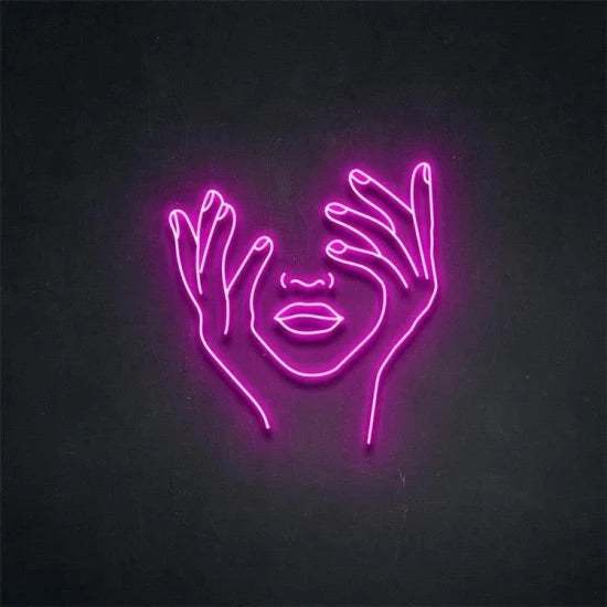 Neon pink light artwork of a face with hands on dark wall background Volto con mani neon